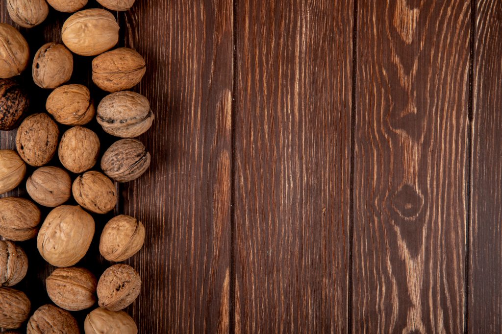 top view whole walnuts scattered wooden background with copy space